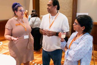 Three people standing and chatting