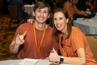 Two people sitting at a table and smiling