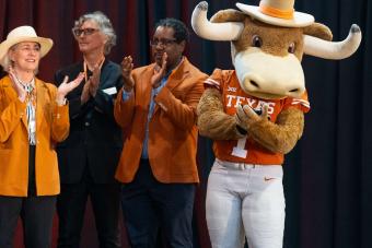 Hook ‘Em mascot on stage with three people