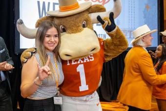 Hook ‘Em mascot posing with someone and showing Hook ‘Em hand signs