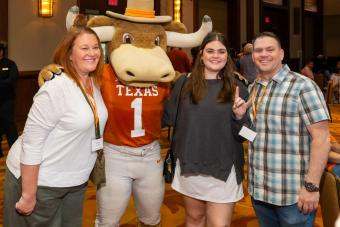 Hook ‘Em mascot posing with three people