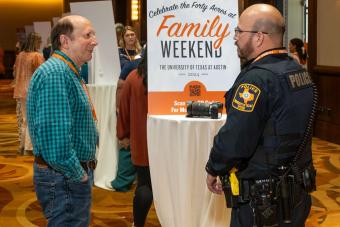 Man standing and chatting with officer at UTPD table