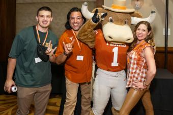 Hook ‘Em mascot posing with three people