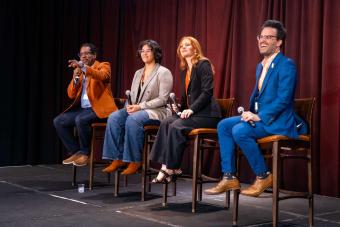 Four panelists seated on stage