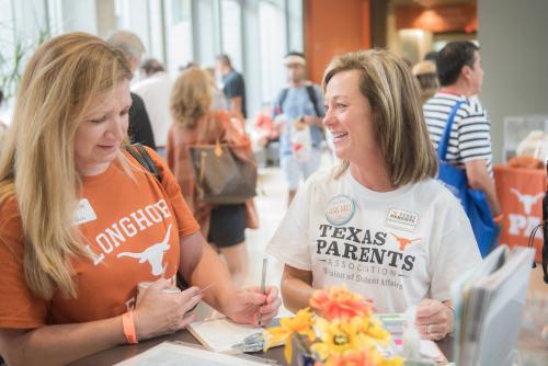 Longhorn mom signing up for Texas Parents membership with the help of a TPA representative